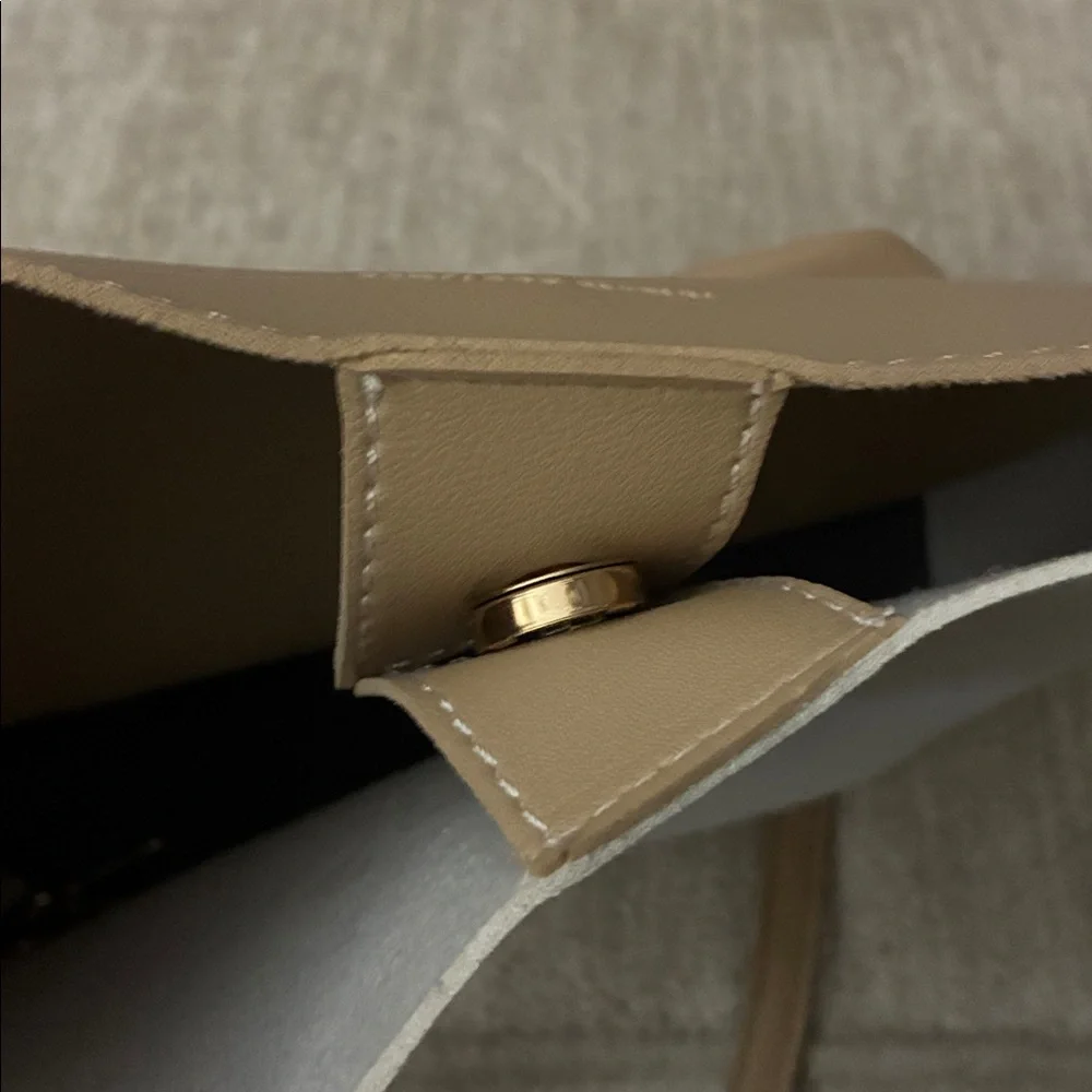 Tan purse‎ with sleek design and smooth finish.